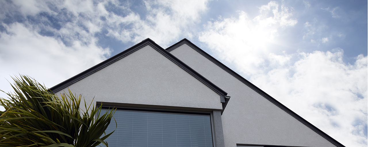 photo of roofline with sky and clouds behind
